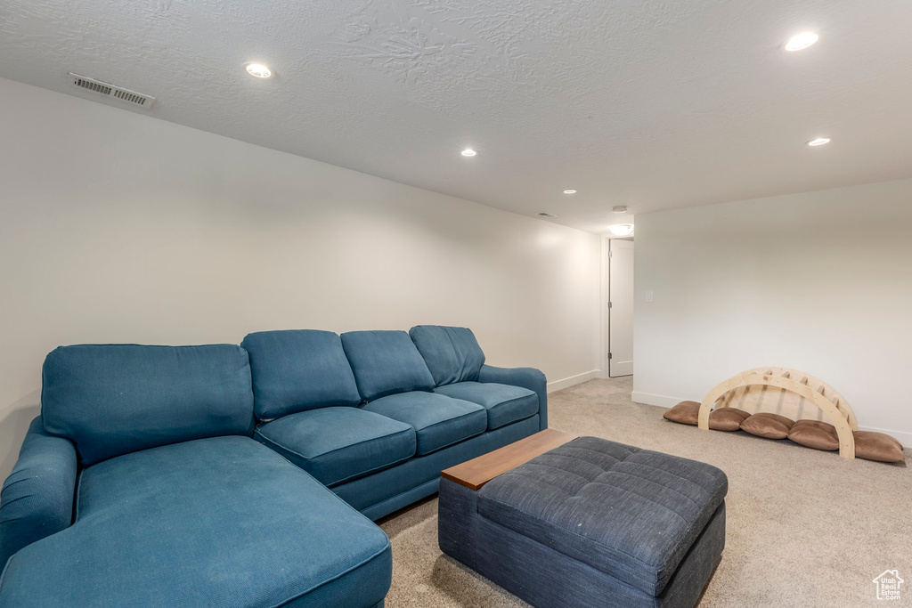 Living room with light carpet, recessed lighting, and baseboards