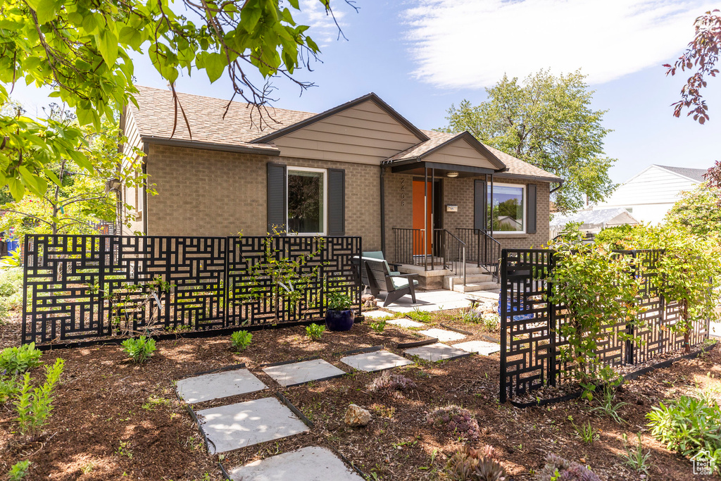 View of front of house with brick siding and roof with shingles