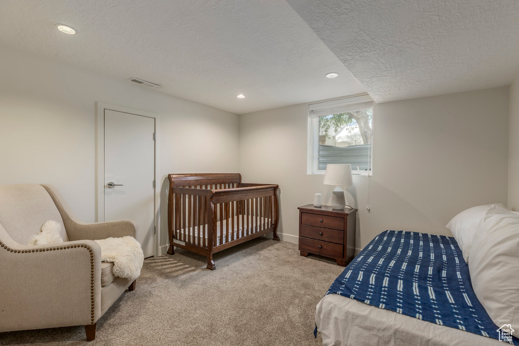 Carpeted bedroom with a textured ceiling, recessed lighting, and baseboards