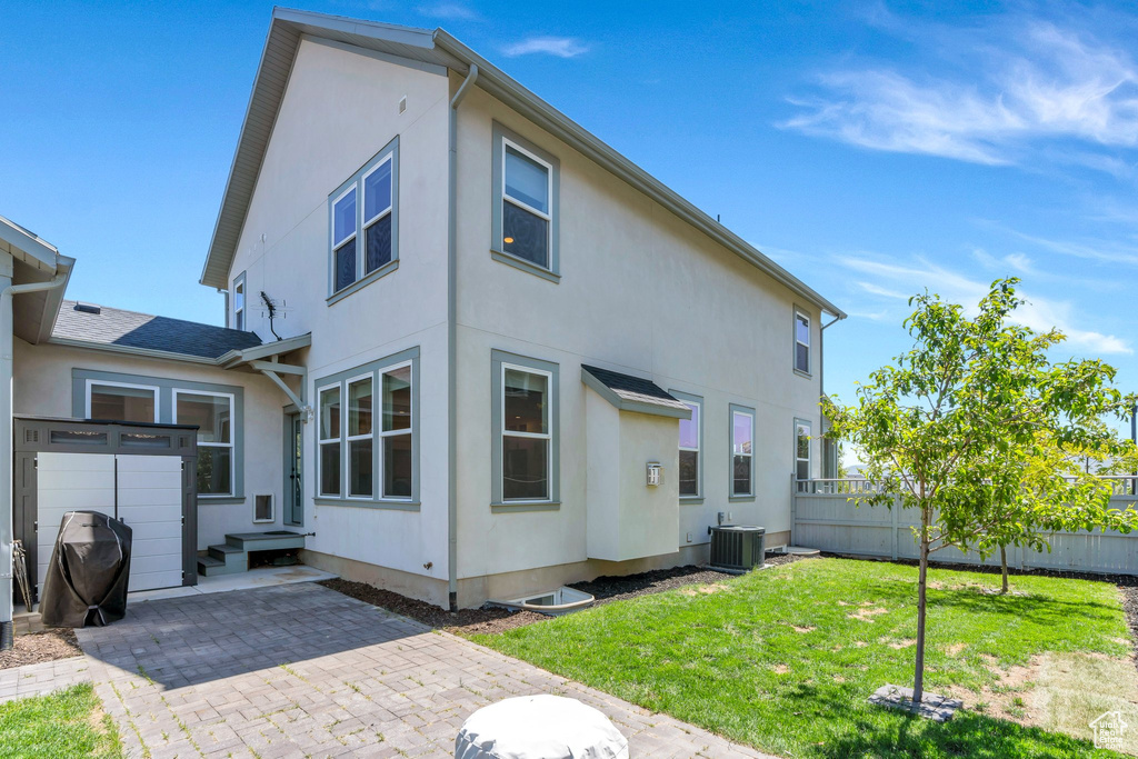 Rear view of house with central air condition unit, a patio area, and stucco siding