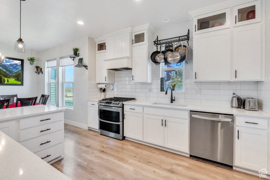 Kitchen with appliances with stainless steel finishes, a sink, plenty of natural light, backsplash, and recessed lighting