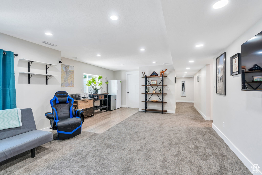 Living area featuring light colored carpet, recessed lighting, and baseboards