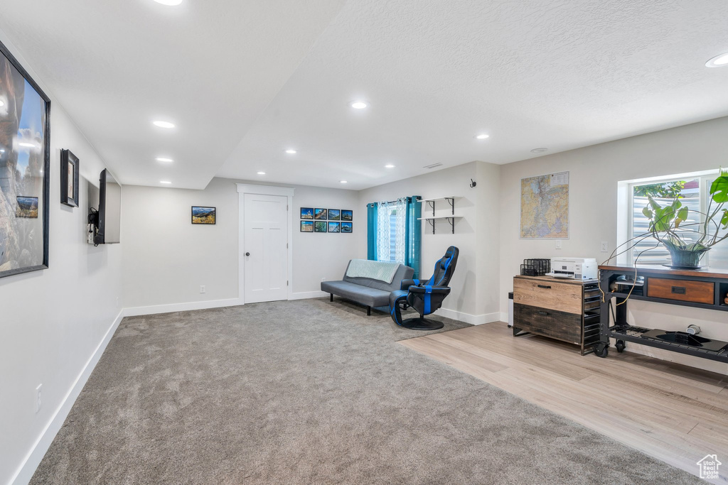Sitting room with baseboards, recessed lighting, carpet flooring, wood finished floors, and a textured ceiling
