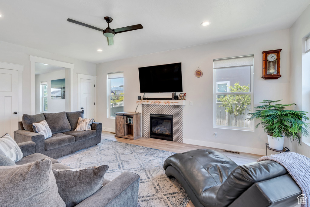 Living room featuring ceiling fan, plenty of natural light, light wood-style floors, recessed lighting, and baseboards