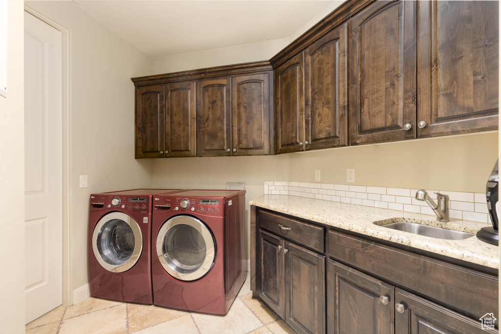 Laundry room featuring cabinet space, washing machine and dryer, and light tile patterned floors