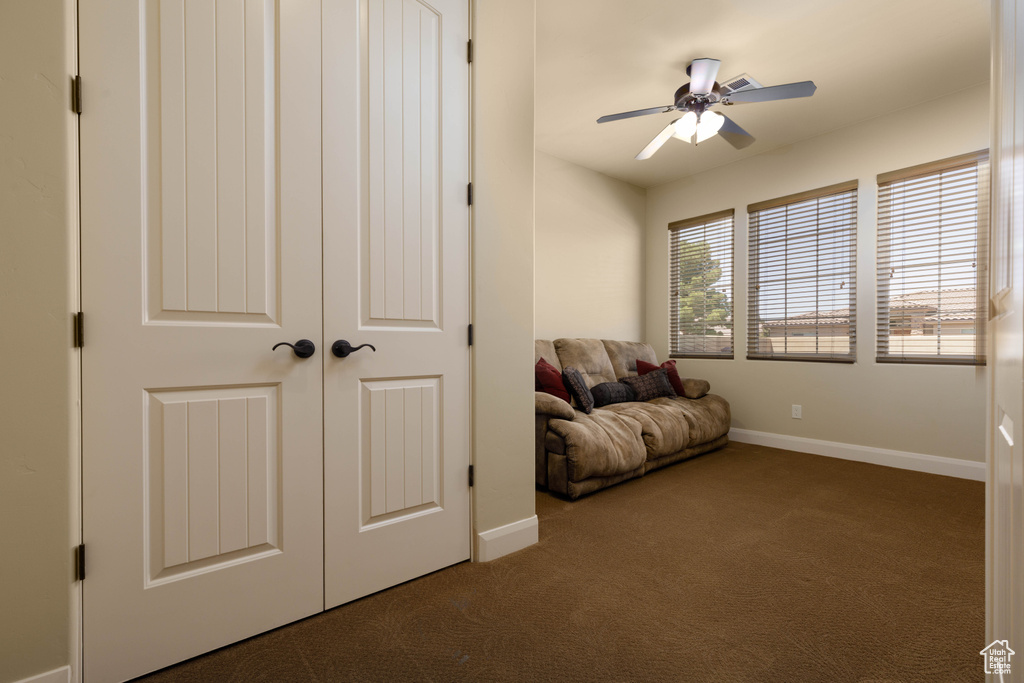 Sitting room with carpet flooring, ceiling fan, and baseboards