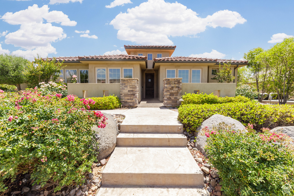 Mediterranean / spanish home featuring a tiled roof and stucco siding