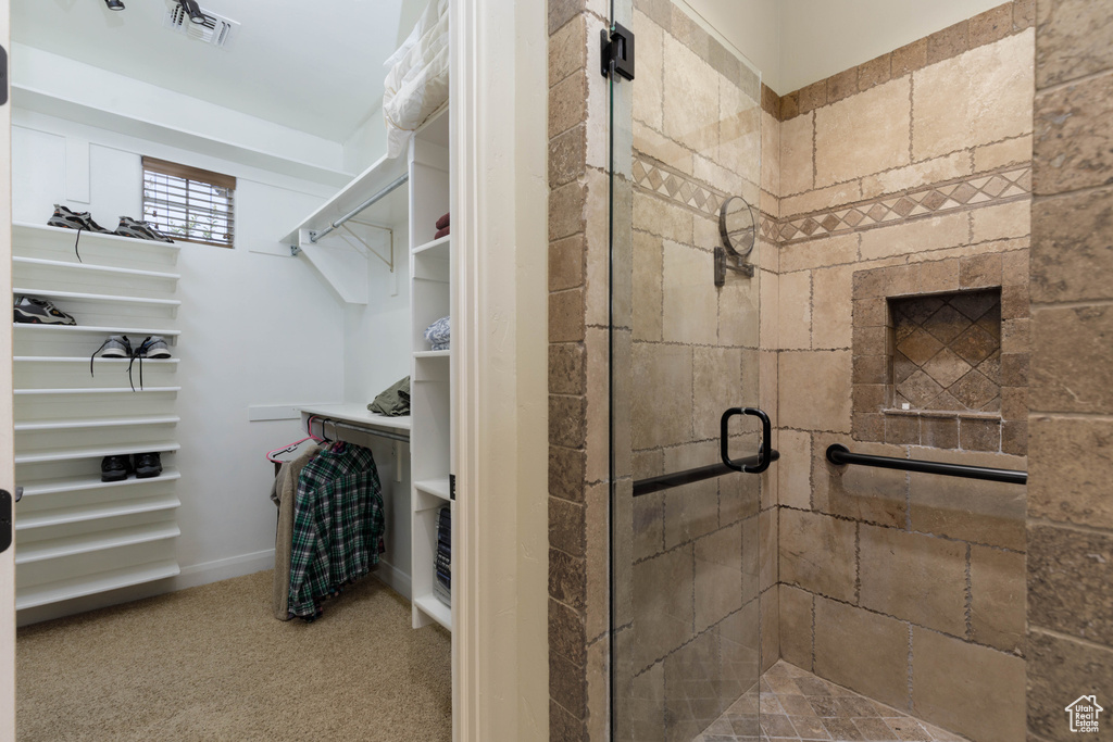 Bathroom featuring a stall shower and a walk in closet