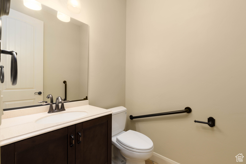 Bathroom featuring toilet, vanity, and baseboards
