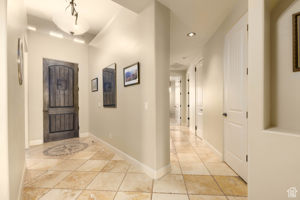 Foyer featuring recessed lighting, light tile patterned floors, and baseboards