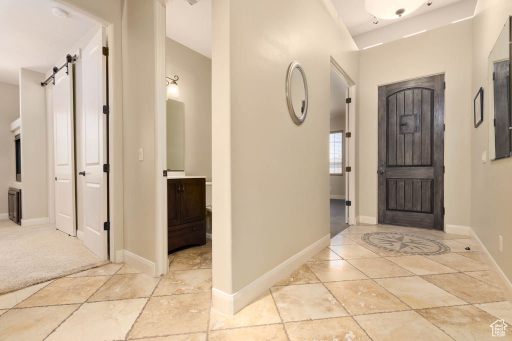 Entryway featuring a barn door and baseboards