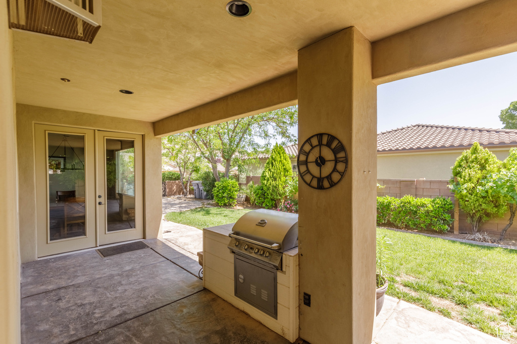 Fenced backyard with french doors, a patio, and area for grilling