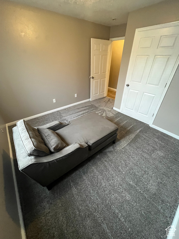 Bedroom featuring baseboards and dark colored carpet