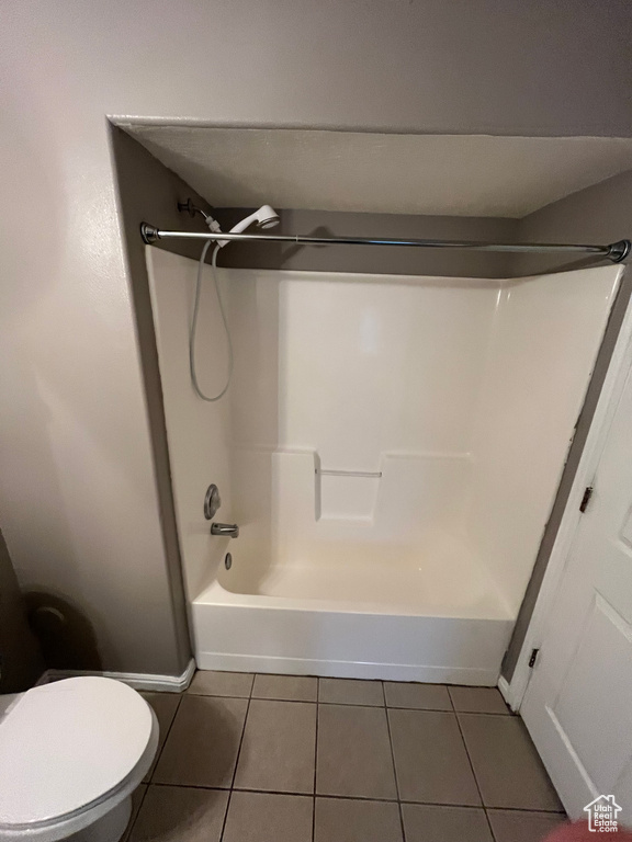 Bathroom featuring tile patterned flooring, shower / washtub combination, toilet, and baseboards
