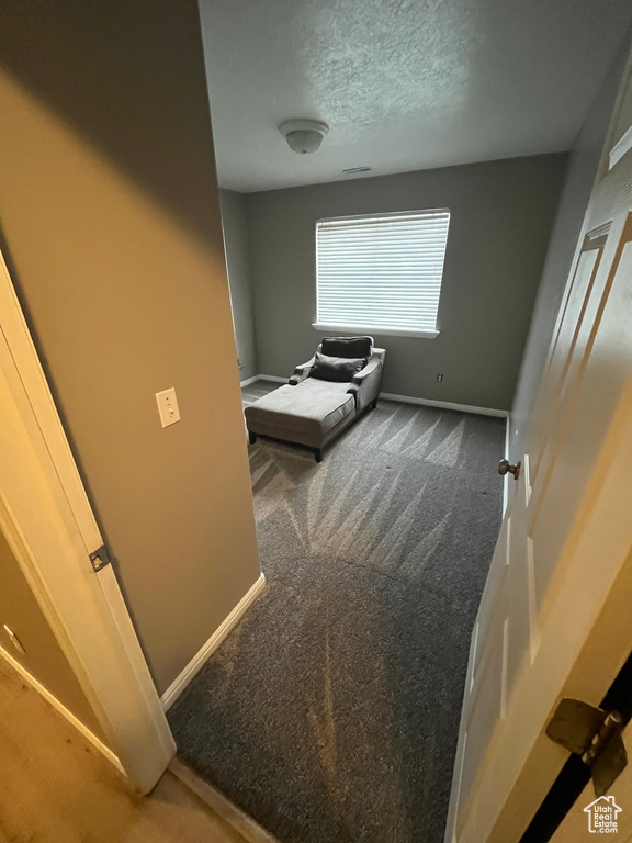 Carpeted bedroom featuring baseboards and a textured ceiling
