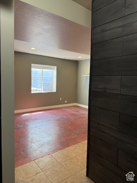 Empty room featuring recessed lighting, baseboards, and a textured ceiling