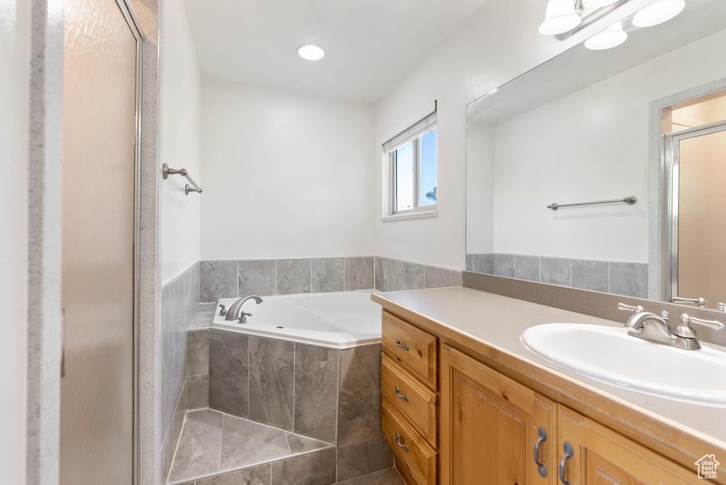Full bathroom featuring vanity, a bath, and a shower stall