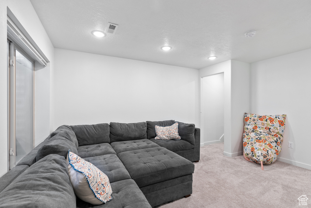 Carpeted living area with recessed lighting and baseboards