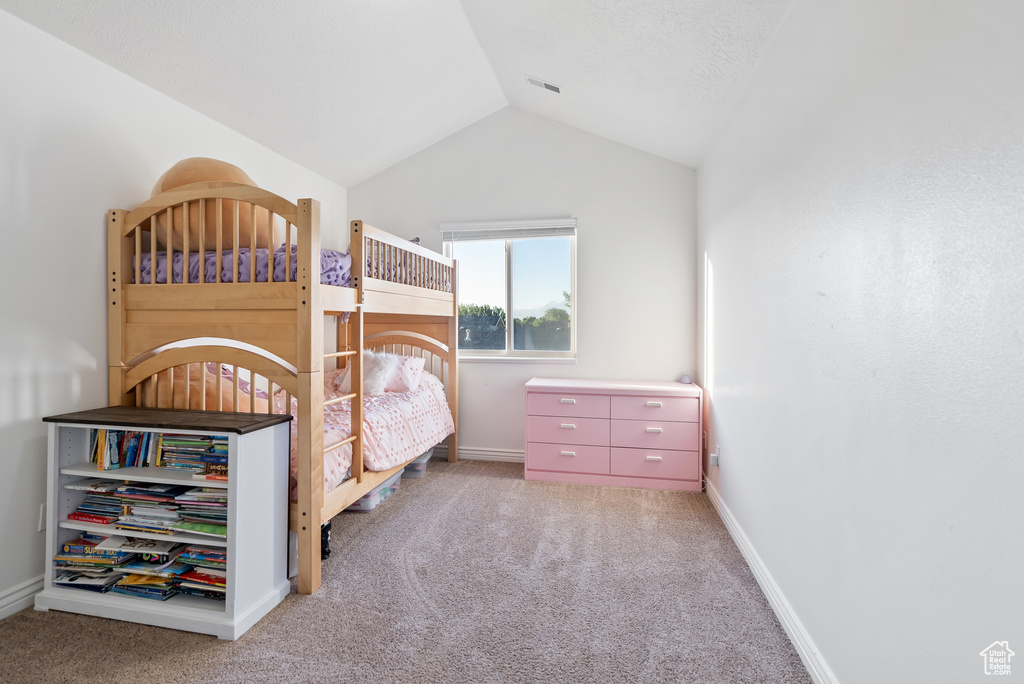 Bedroom featuring carpet floors, vaulted ceiling, and baseboards