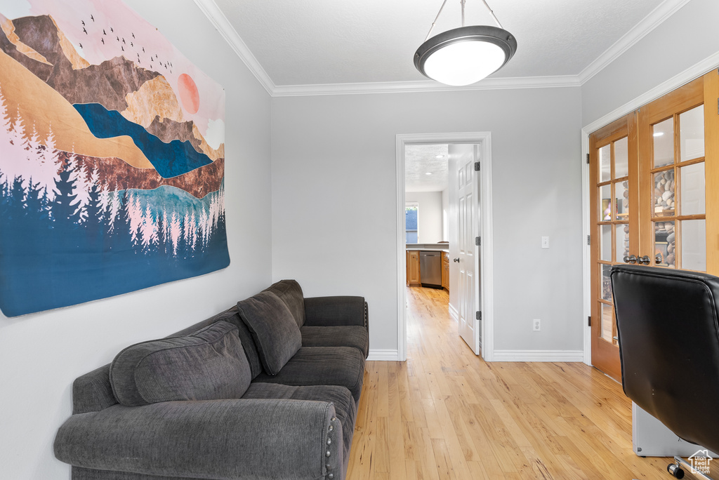Office space with light wood-style floors, baseboards, and crown molding