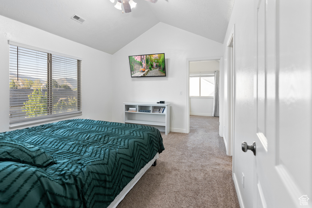 Bedroom with light carpet, vaulted ceiling, baseboards, and ceiling fan