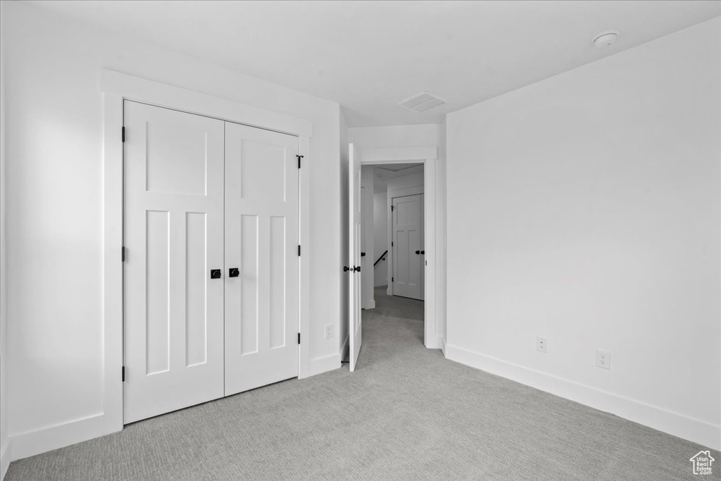 Unfurnished bedroom featuring carpet floors, baseboards, and a closet