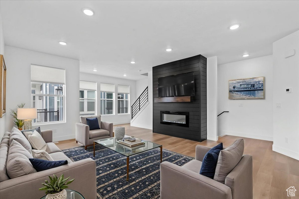 Living area featuring a fireplace, wood finished floors, recessed lighting, and baseboards