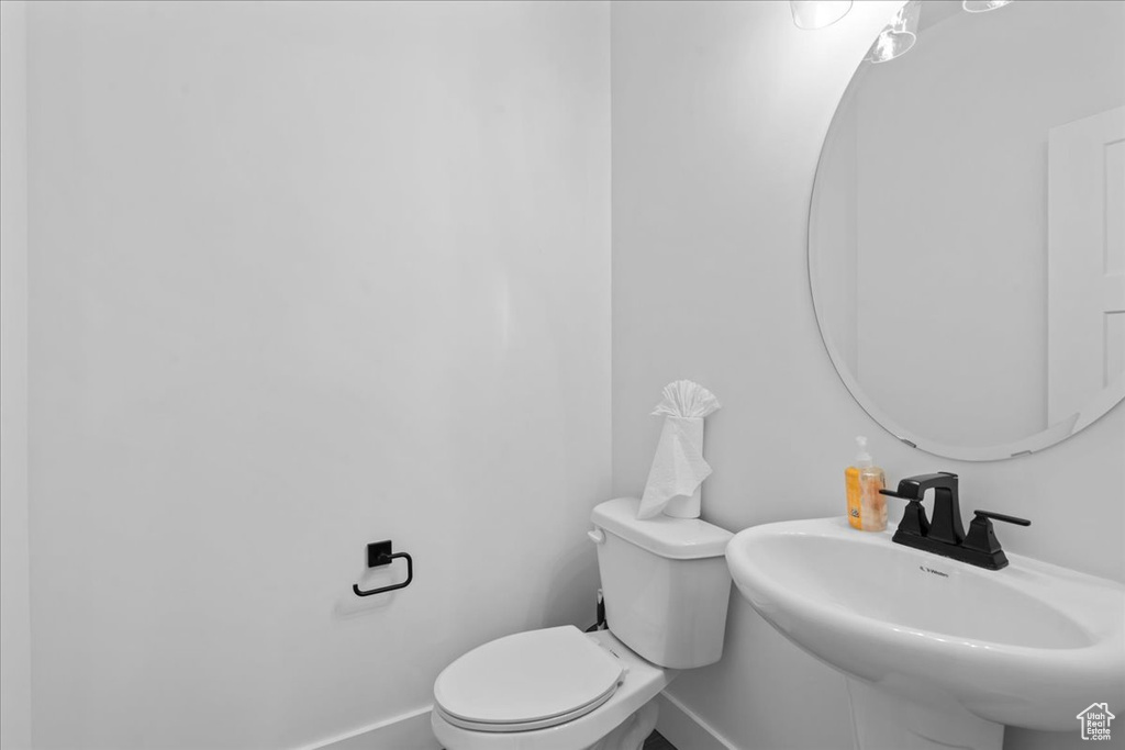 Bathroom featuring baseboards, a sink, and toilet