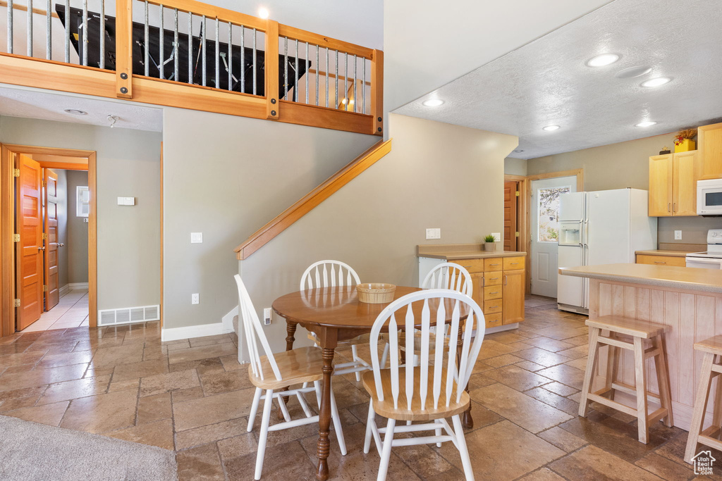 Dining room with stone tile floors, stairway, recessed lighting, and baseboards
