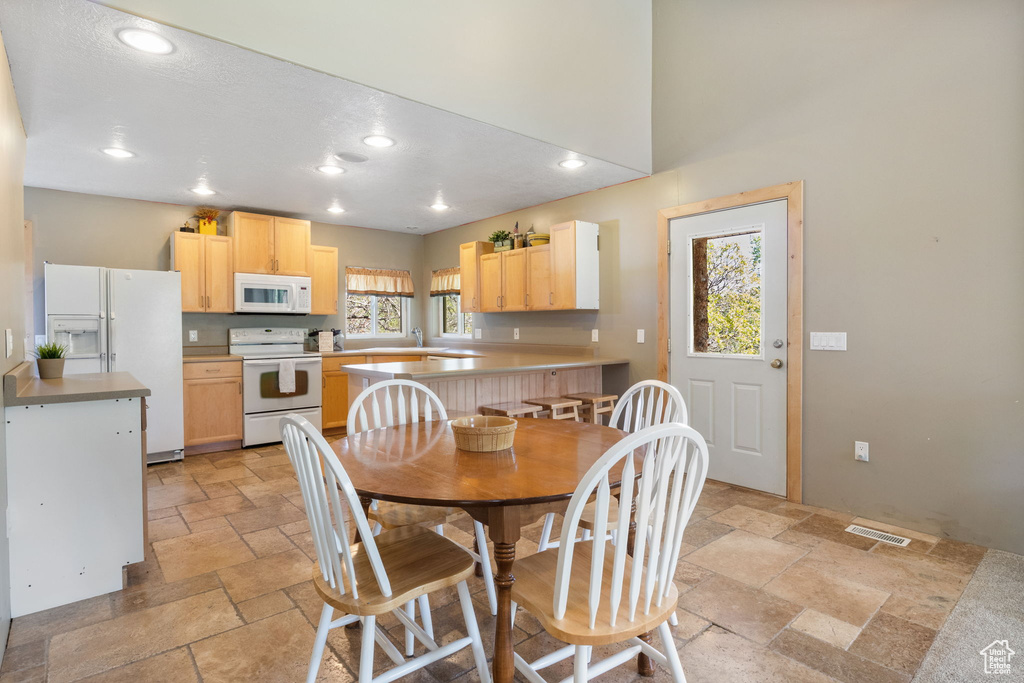 Dining space with stone tile flooring and recessed lighting