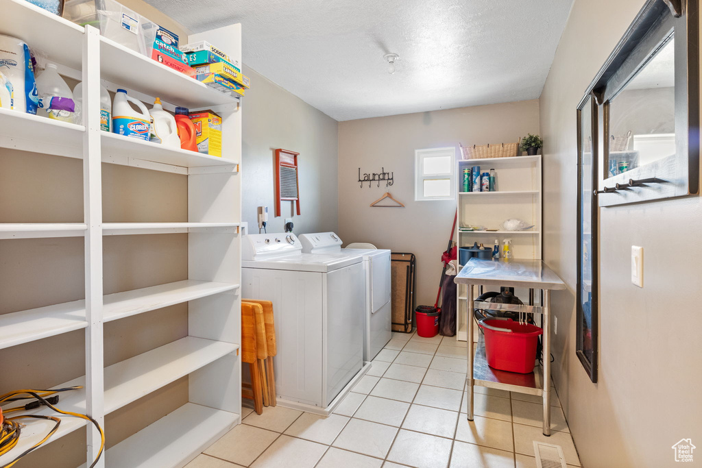 Laundry area featuring independent washer and dryer and tile patterned floors