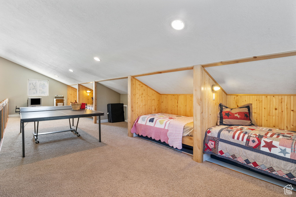 Bedroom featuring carpet flooring, lofted ceiling, wood walls, and recessed lighting