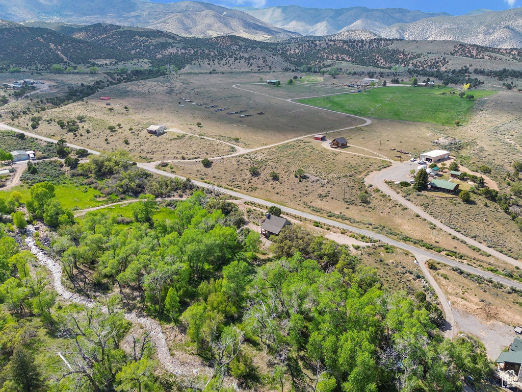 Aerial view of property's location featuring a mountain backdrop and rural landscape