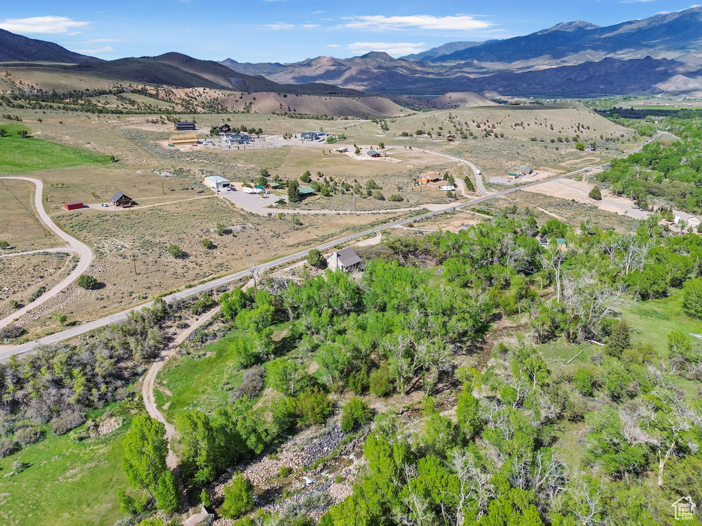 Aerial view of property and surrounding area featuring mountains and rural landscape