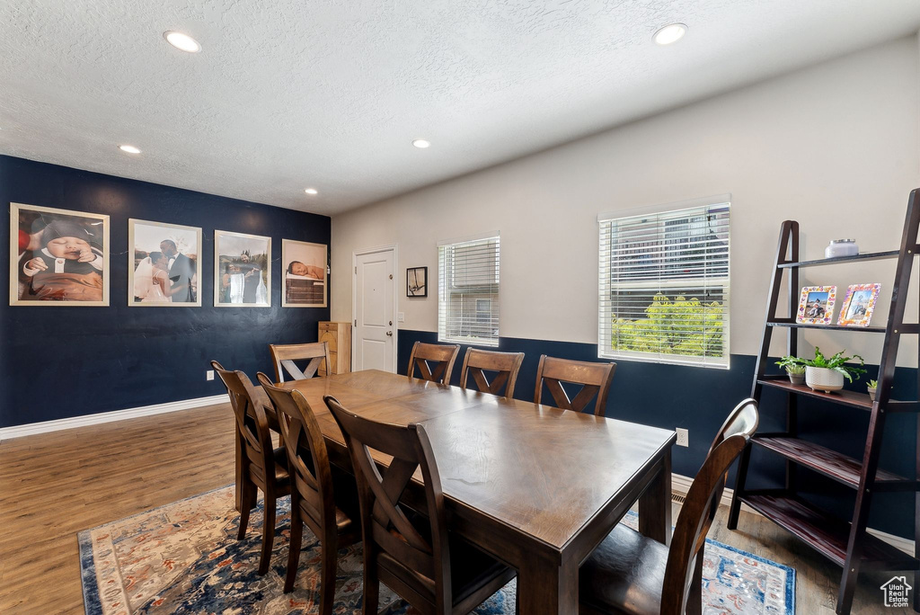 Dining room with wood finished floors, recessed lighting, a textured ceiling, and baseboards