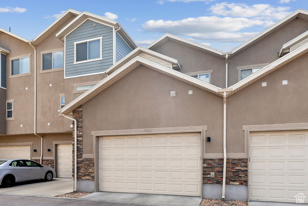 View of property with stone siding and stucco siding