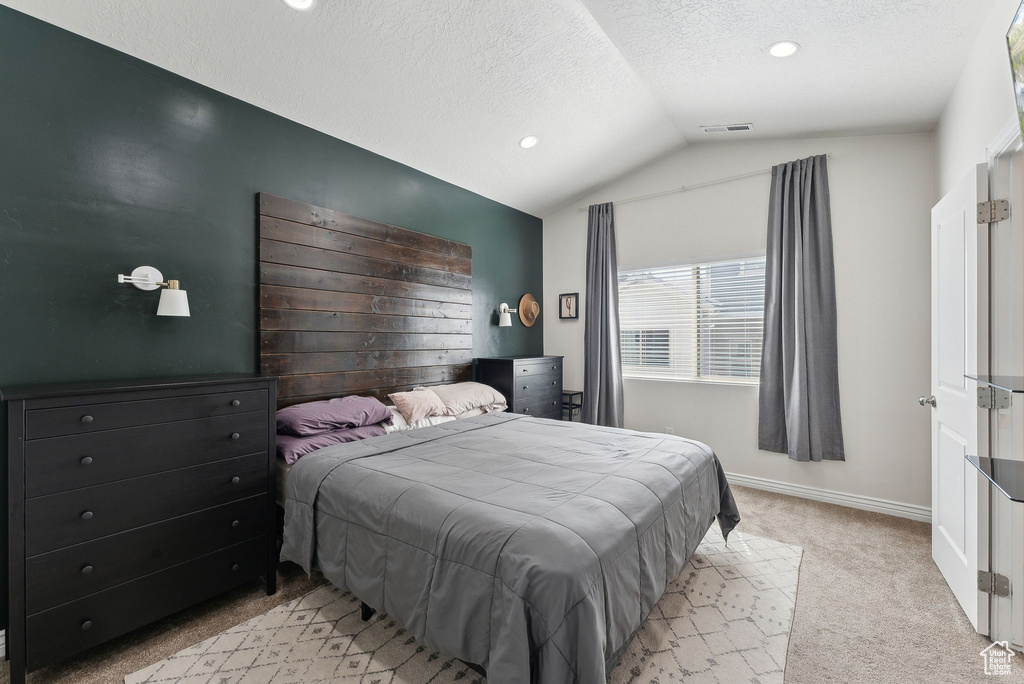 Bedroom with light colored carpet, vaulted ceiling, a textured ceiling, baseboards, and recessed lighting