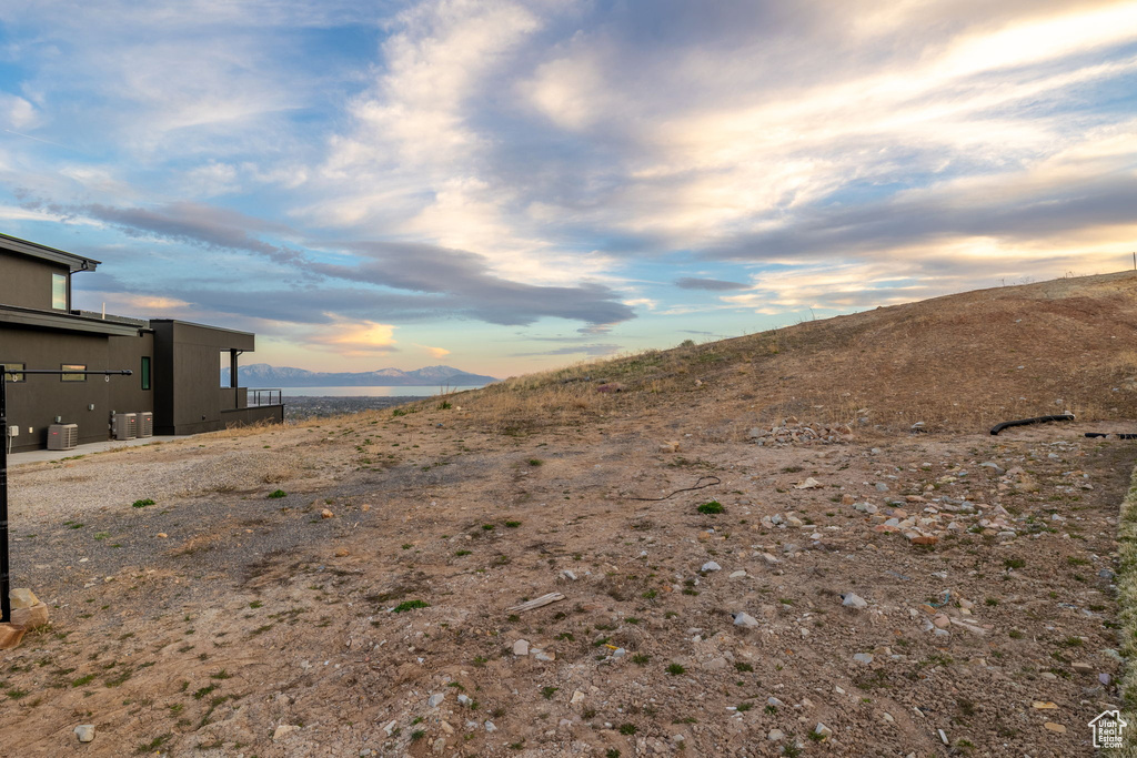 Yard at dusk featuring a mountain view and central air condition unit
