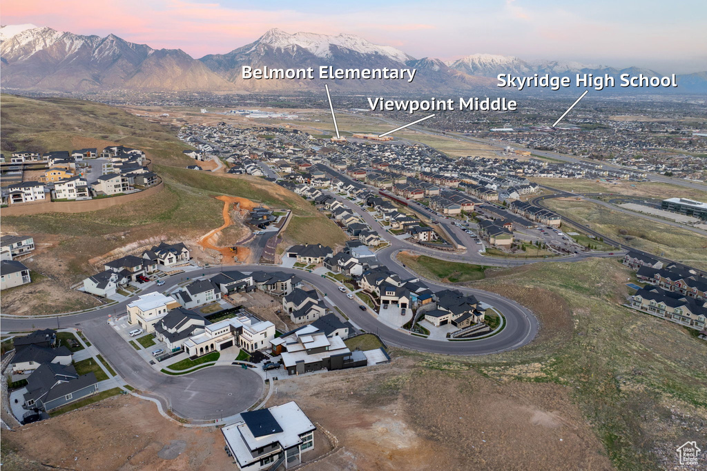 Aerial view of property and surrounding area featuring a mountainous background
