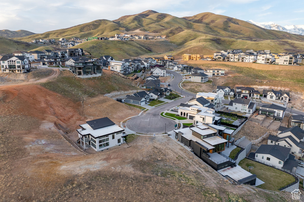 Aerial view of property and surrounding area featuring nearby suburban area and a mountainous background