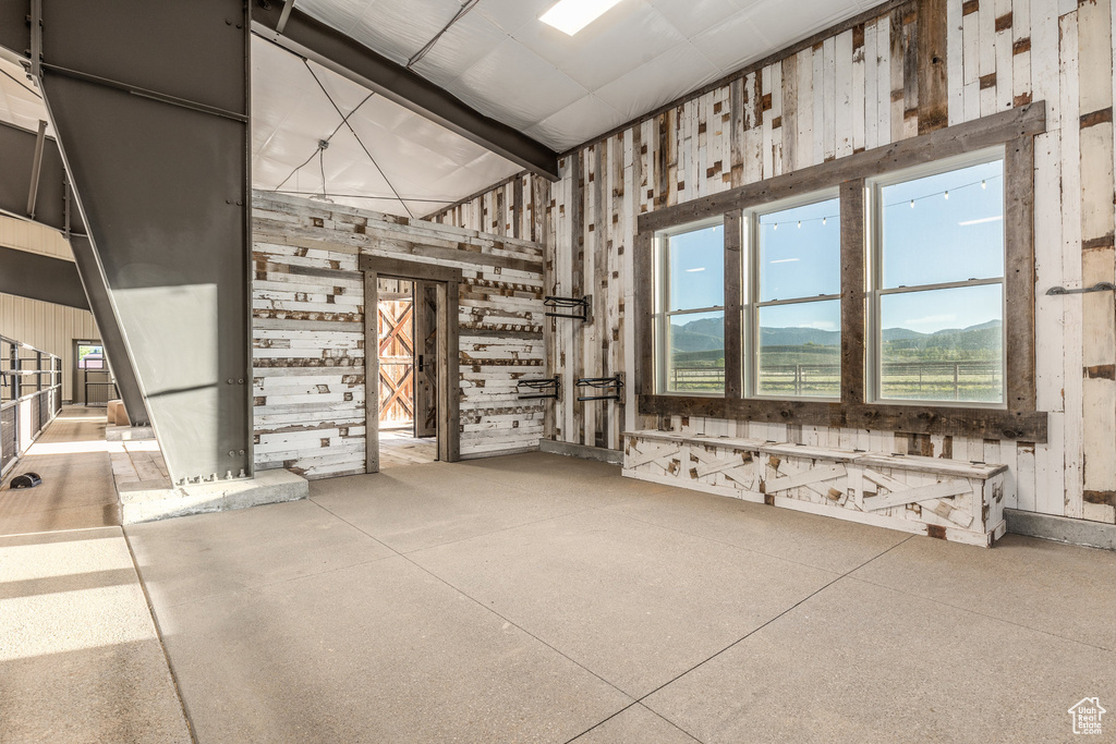 Miscellaneous room with a high ceiling and wood walls