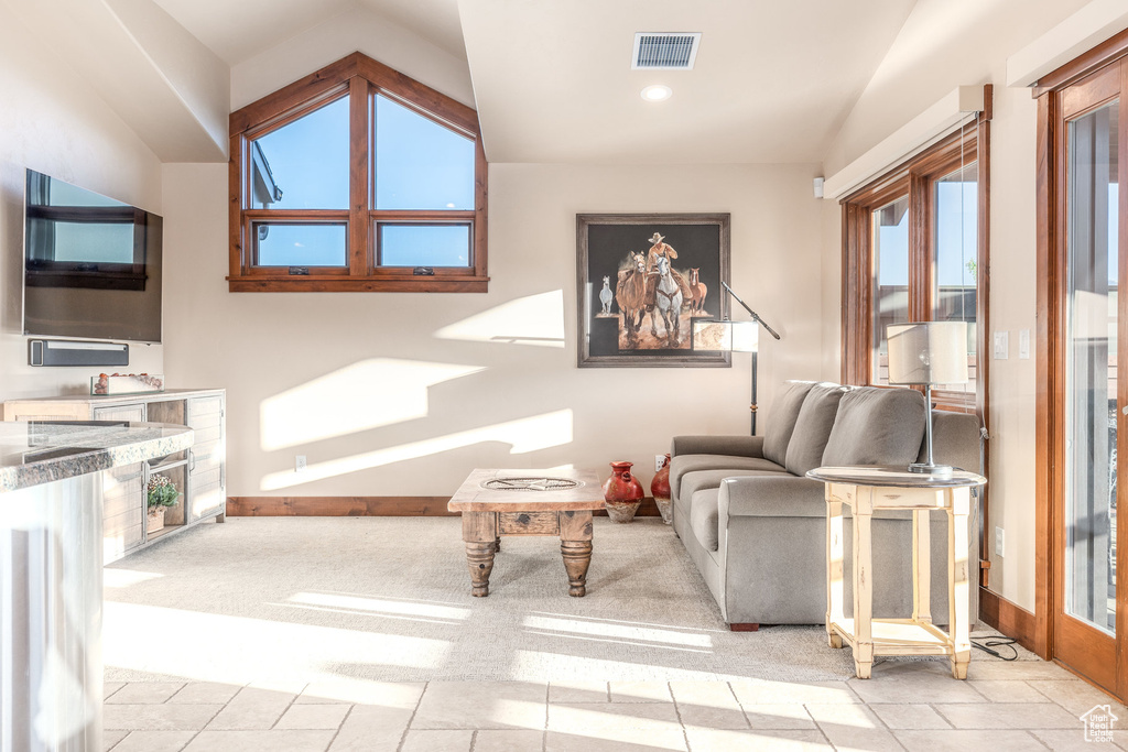 Living room with vaulted ceiling, baseboards, recessed lighting, and light tile patterned floors