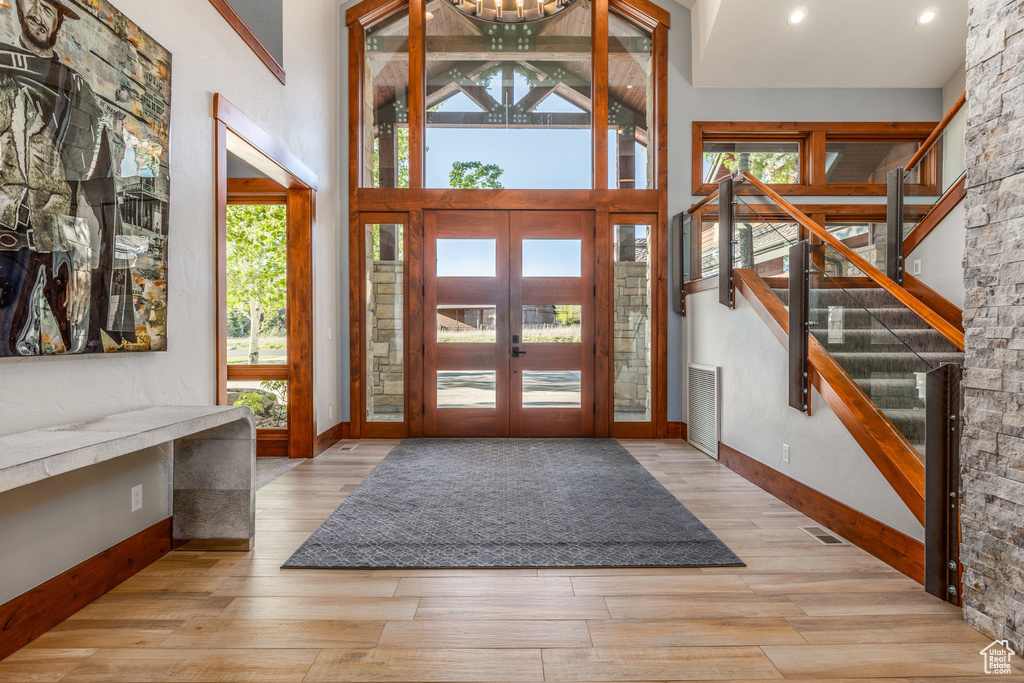Entrance foyer with wood finished floors, baseboards, and french doors