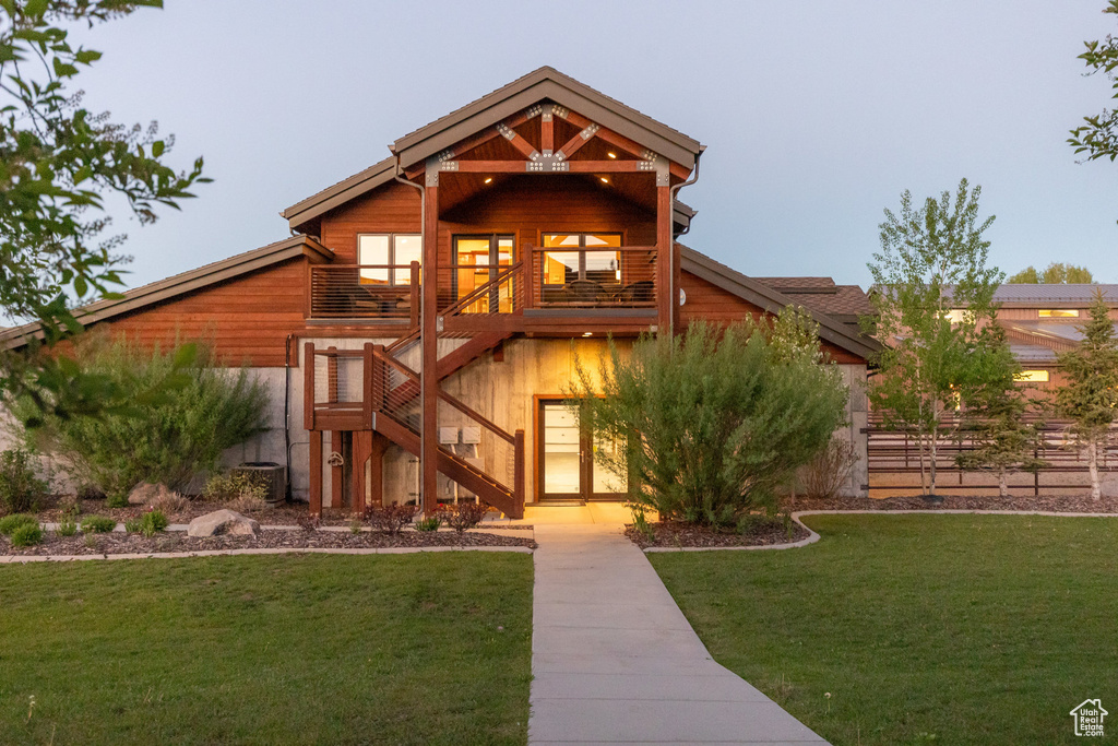 View of front of property featuring stairs, a front yard, and a balcony