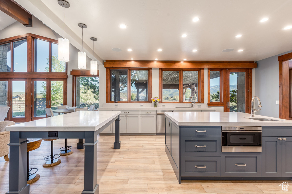 Kitchen featuring a sink, gray cabinets, light countertops, recessed lighting, and light wood-style flooring