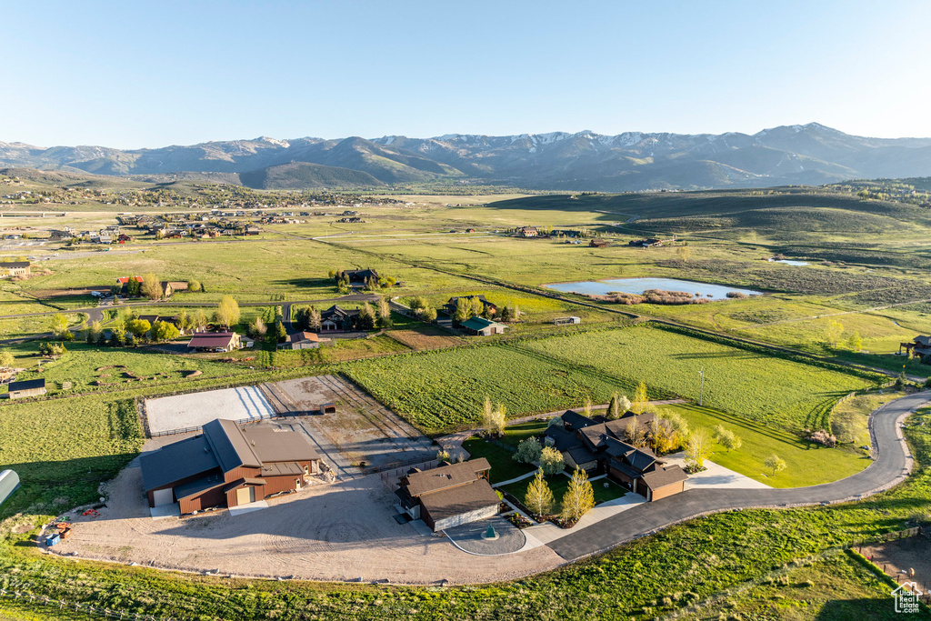 Aerial view of property and surrounding area with rural landscape and a water and mountain view