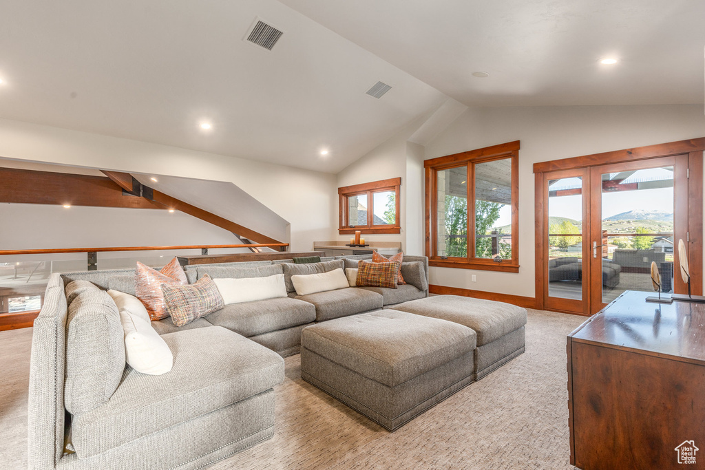 Living area with lofted ceiling, french doors, recessed lighting, baseboards, and light colored carpet