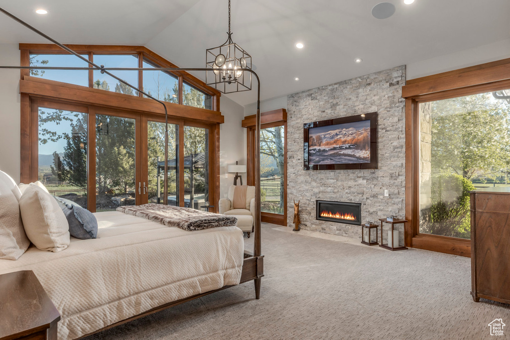 Bedroom featuring a chandelier, vaulted ceiling, a fireplace, carpet flooring, and recessed lighting
