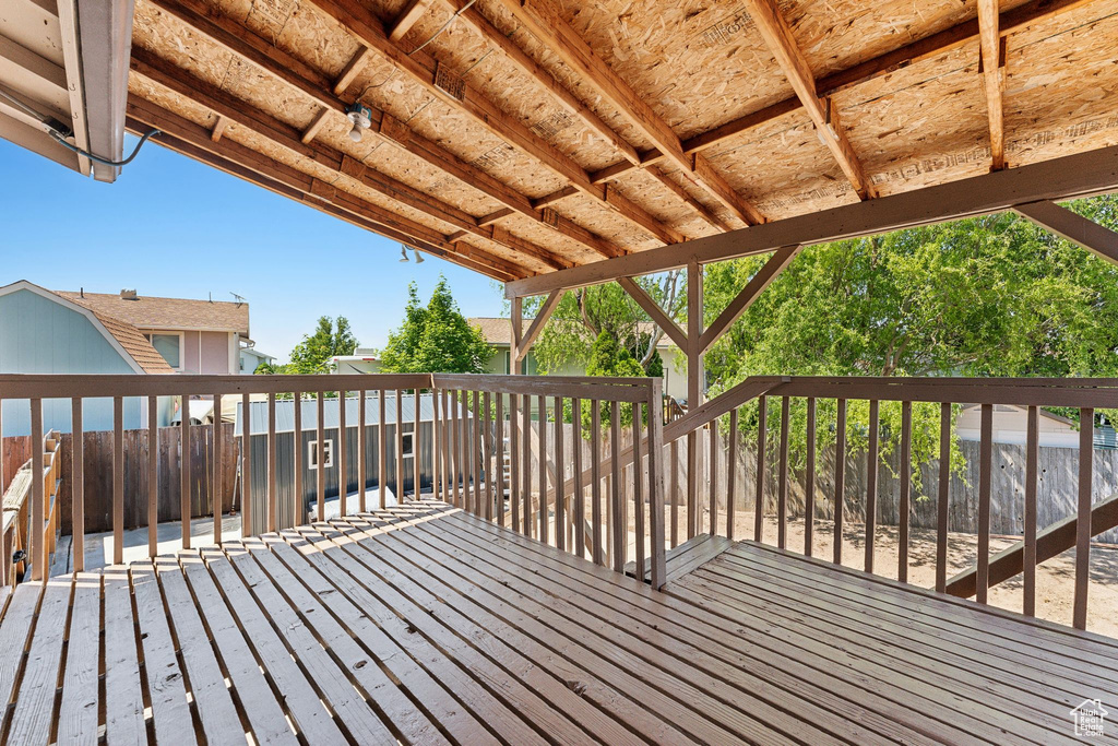 Wooden terrace with a fenced backyard