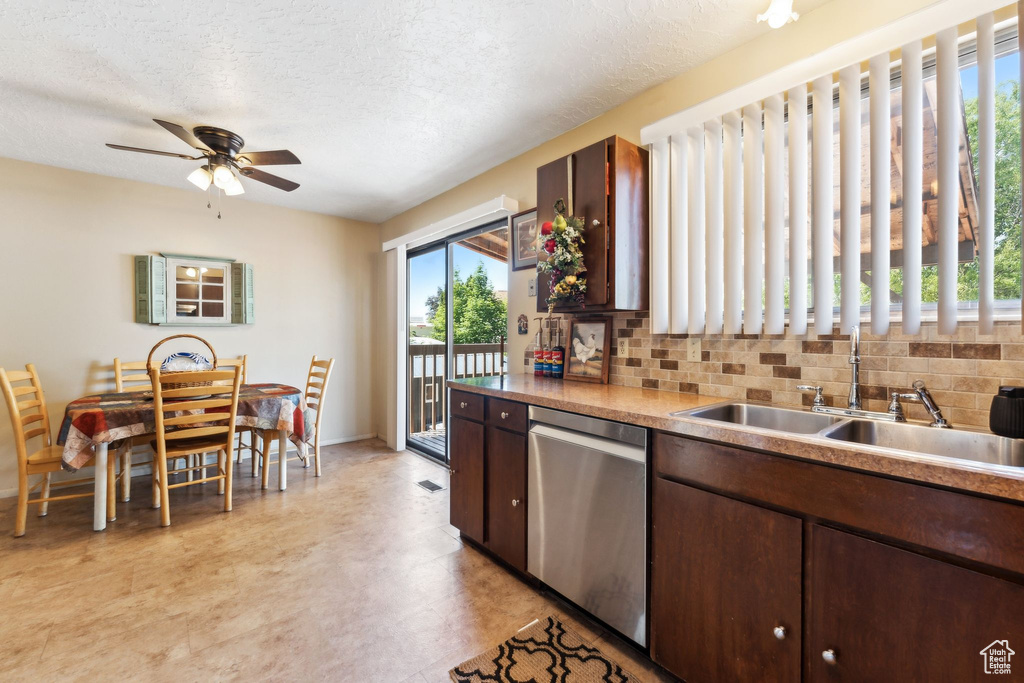 Kitchen featuring stainless steel dishwasher, a sink, ceiling fan, backsplash, and dark brown cabinets